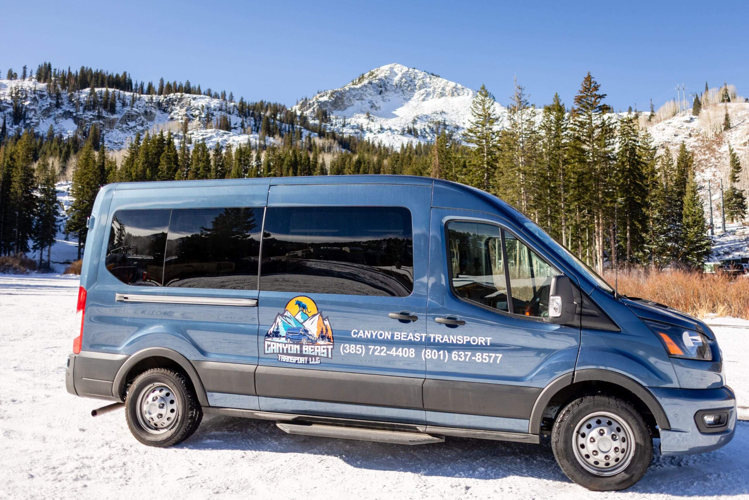 Blue transport van in snowy landscape.