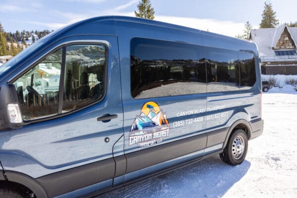 Blue transport van in snowy landscape.